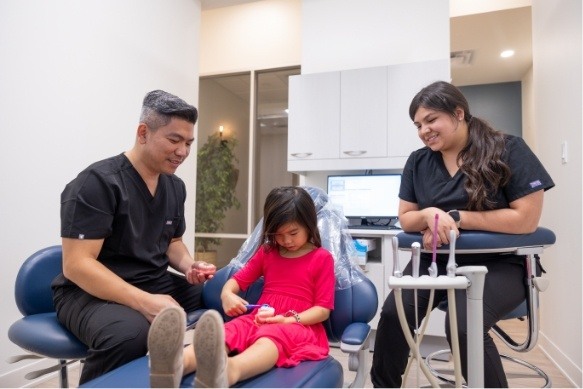 Children's dentist providing dental checkup and teeth cleaning for kids